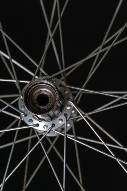 Bicycle repair cleaning and replacement of grease in the rear\
hub of the bike the rear wheel of the bike on a black background\
spokes and hubs are gray modern workshop freehub close up