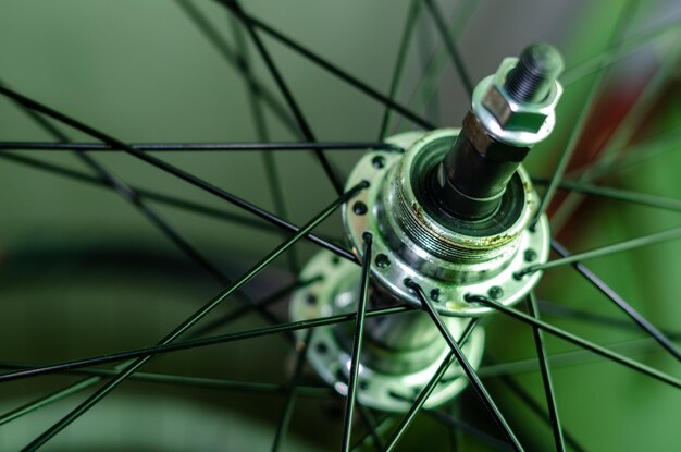 Bicycle repair workshop on the hook hang new wheels the hub is
black and the spokes and rim are silver the old bike here is gets a
second chance parts closeup