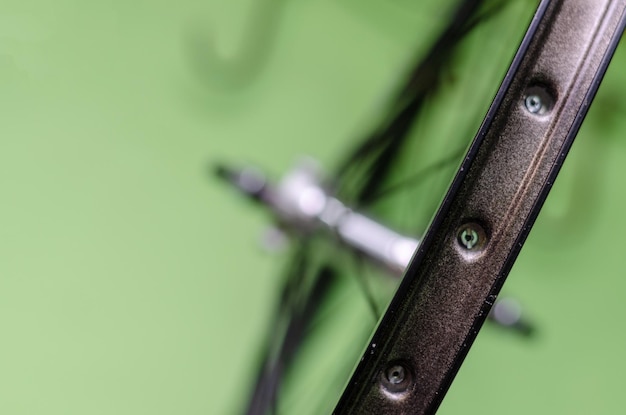 Мастерская по ремонту велосипедов На крюке висят новые колеса Ступица черная, а спицы и обод серебристые Старый велосипед здесь получает второй шанс Детали крупным планом