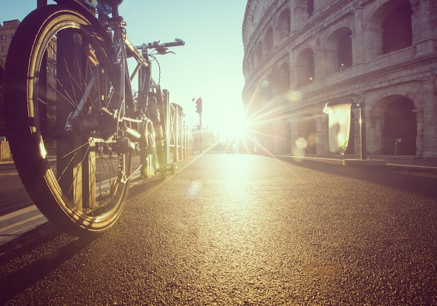 Bicicletta ferma davanti al colosseo di roma italia.