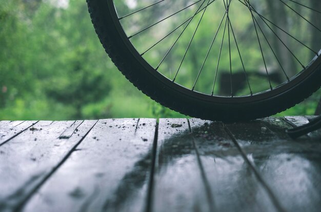 Bicycle wheel on the wooden floor under the rain