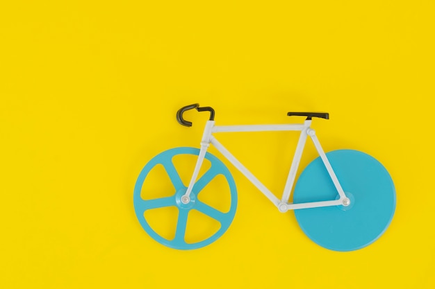 Bicycle with blue wheels on a bright yellow 