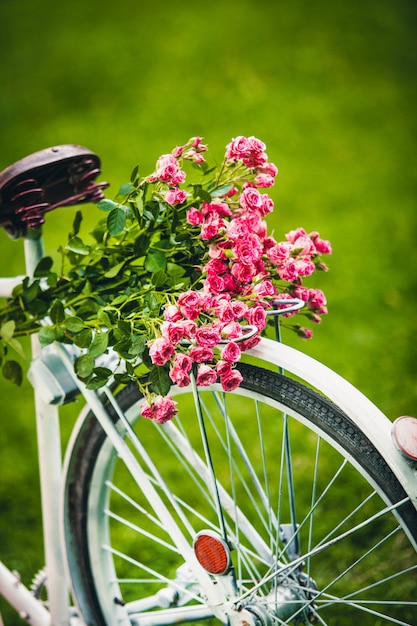 Bicycle with bouquets of flowers for a girl is standing in the park