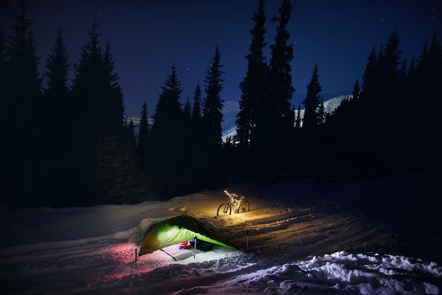 Bicycle with Christmas lights and tent at night