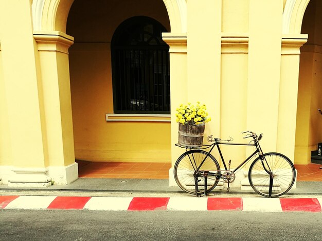 Photo bicycle with flowers against yellow wall