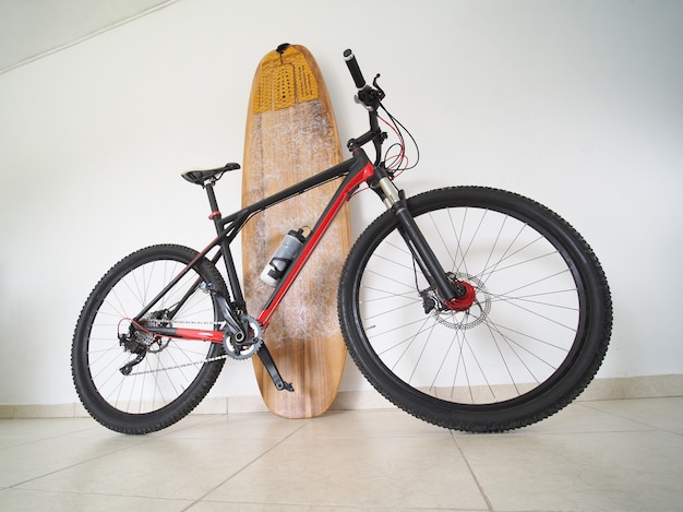 Bicycle with a surfboard at home. Sport concept.