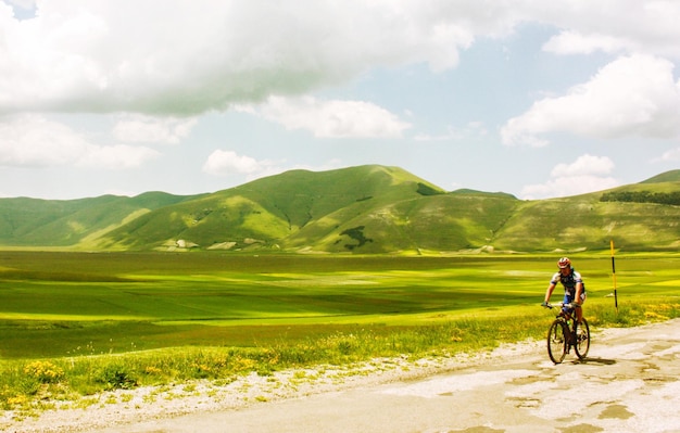 bicycling on country road along landscape