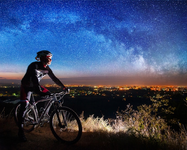 Bicyclist with mountain bike on top of the hill