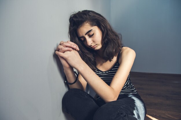 Biddende jonge vrouw in de kamer