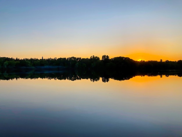 Biebrzarivier bij zonsondergangbezinning in de watersilhouetten van