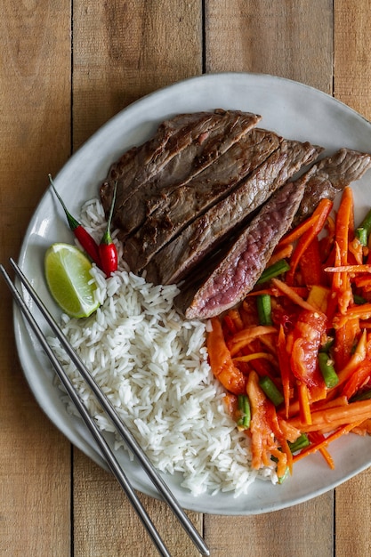 Foto biefstuk met salade en rijst. eten en drinken, bovenaanzicht