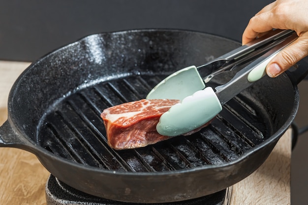 Biefstuk met tang op de grillpan