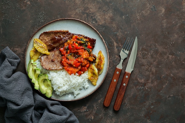 biefstuk met tomatensaus, rijst, avocado, bananen friet