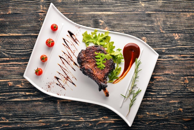 Biefstuk op een bot met tomaten en een hazelnoot Steak Fiorentino Op een houten ondergrond Vrije ruimte voor uw tekst Bovenaanzicht