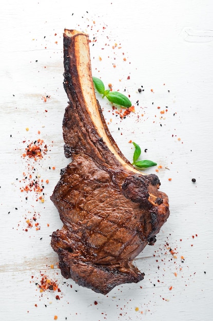 Biefstuk op het bot tomahawk steak Op een witte houten achtergrond Bovenaanzicht Gratis kopieerruimte