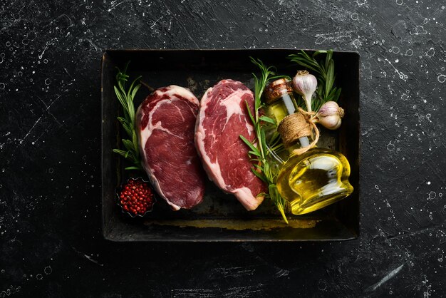 Biefstuk ribeye in een metalen ovenschaal Bovenaanzicht Vrije ruimte voor uw tekst