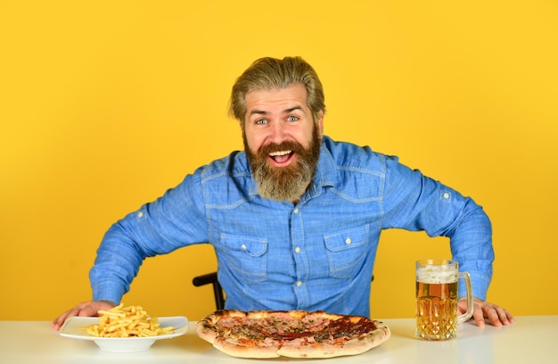 Bier en eten Kon niet beter Diner in pub Hongerige man gaat pizza eten en bier drinken Eindelijk pizzatijd Pizzeria restaurant Vrolijke man bebaarde hipster eet pizza Pizza feestconcept