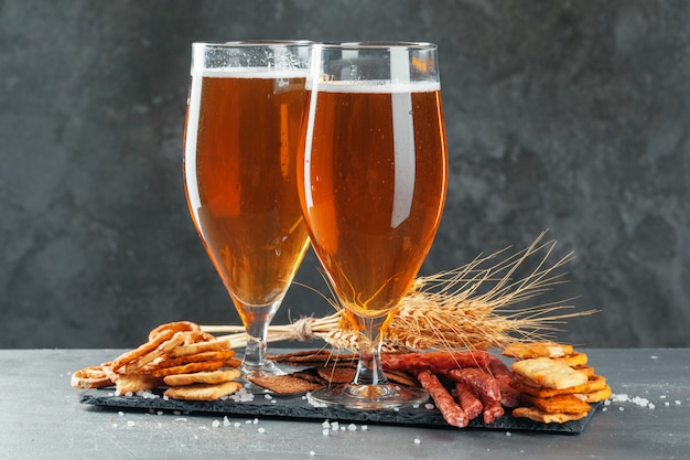 bier en smakelijk bier snacks set. Tafel met mok bier, houten bord met worst