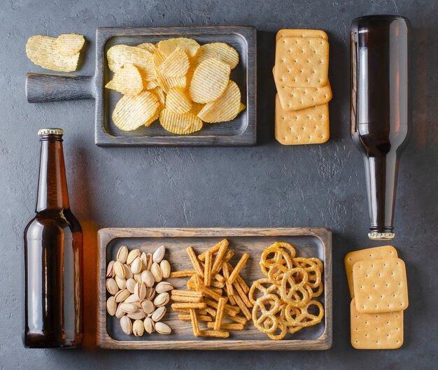 Bier in donkere glazen flessen en zoute snacks