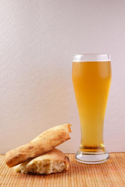 Bier in een hoog glas met stukjes Georgisch brood lavash op een bamboe tapijt Close-up