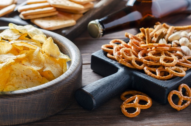 Bier in glazen flessen en zoute snacks voor bier