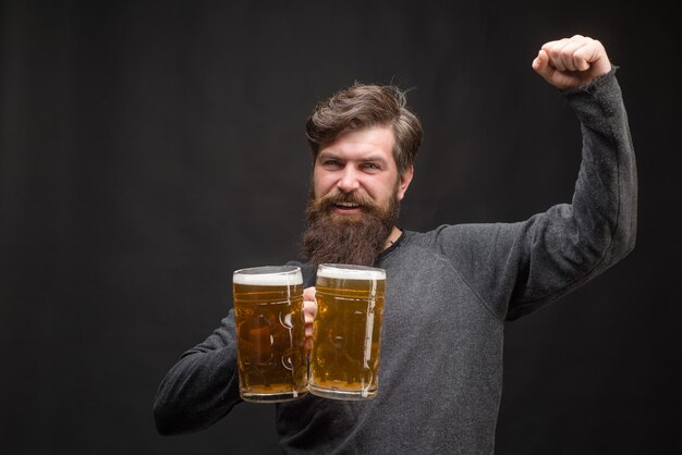 Bier. Oktoberfest. Knappe man bier van glas drinken. Glimlachende bebaarde hipster die ambachtelijk bier drinkt. Brouwen. Stijlvolle man in pub. Biercafé.