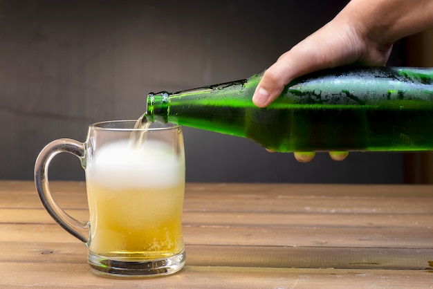 Foto bier stroomt uit een flesje in een glas