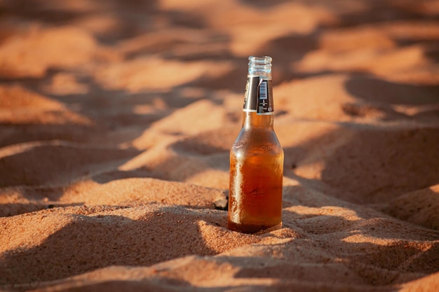 Foto bierflesje bij het strandzand