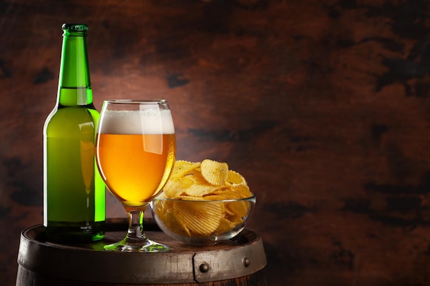 Bierglas fles en chips op houten vat