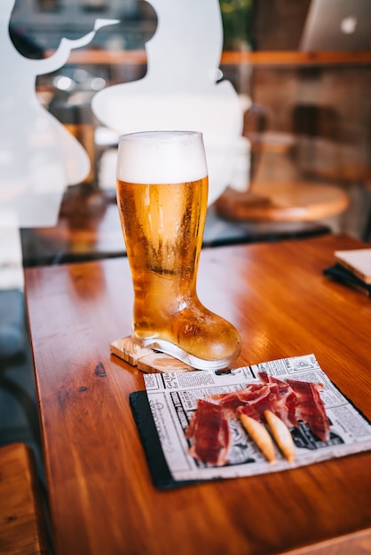 Bierglas laars met heerlijke Spaanse Iberische ham snacks op een houten tafel