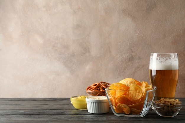 Biersnacks, glas bier, chips, biernoten, sauzen, glas bier op hout, ruimte voor tekst