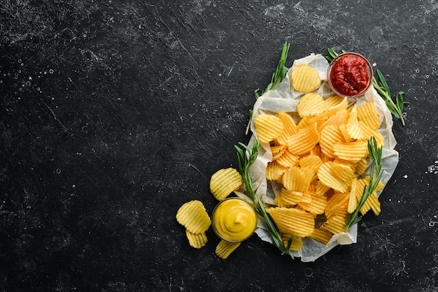 Biersnacks op een zwarte stenen achtergrond Aardappelchips smaak van Bacon Bovenaanzicht