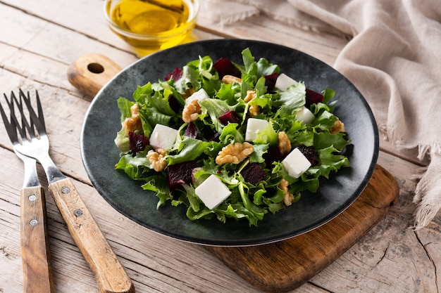 Bietensalade met fetakaas, sla en walnoten op houten tafel