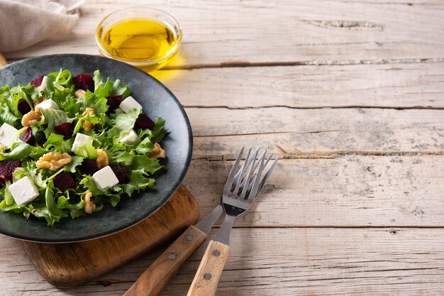 Bietensalade met fetakaas, sla en walnoten op houten tafel