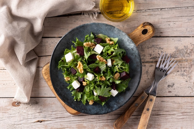 Bietensalade met fetakaas, sla en walnoten op houten tafel