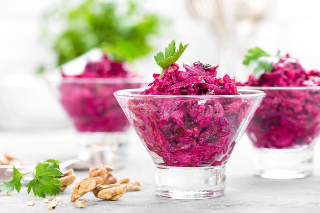 Bietensalade Salade van gekookte bieten Bietensalade met pruimen walnoten en zure room op witte achtergrond