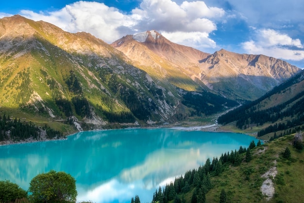 Foto il grande lago di almaty nei monti tien shan del kazakistan un bellissimo paesaggio di montagna in una sera d'estate