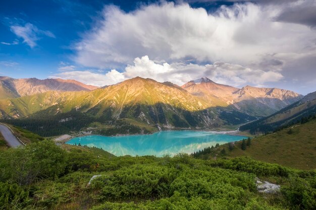 카자흐스탄의 티엔산 산맥에 있는 큰 알마티 호수 (Big Almaty Lake) 는 여름 저녁에 아름다운 산악 풍경의 파노라마입니다.