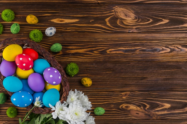 Big basket with Easter eggs on table