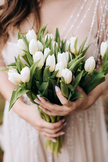 花嫁の手に白いチューリップの大きな美しい花束