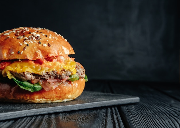 big beautiful homemade juicy burger on a black background