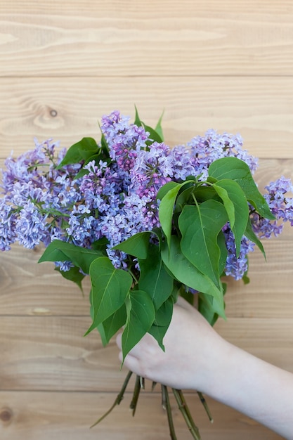 女性の手にライラックの大きな美しい春の花束。