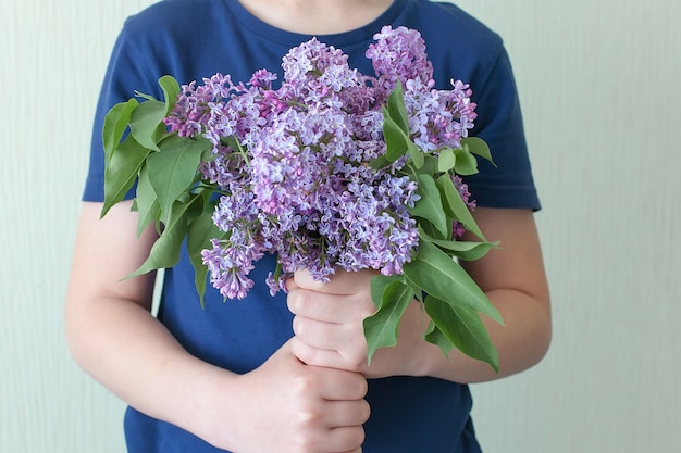 Большой красивый весенний букет сирени в руке женщины.