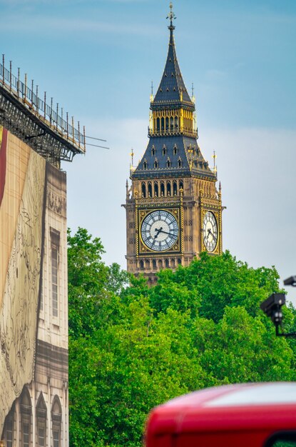 Big Ben, city park and red bus on a summer day.