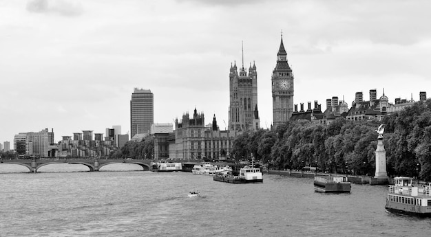 Foto big ben in de stad bij de rivier tegen een bewolkte hemel