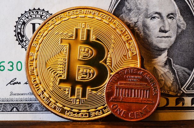 Big bitcoin e centesimo americano sullo sfondo del dollaro americano