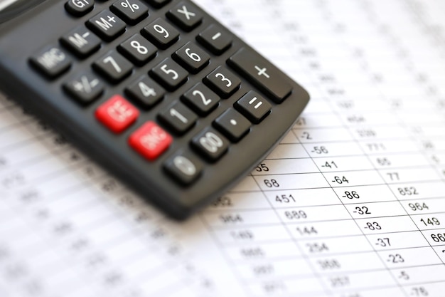 big black calculator lies on financial statement and balance sheeet on desk of auditor close up concept of accounting and audit business taxpaying