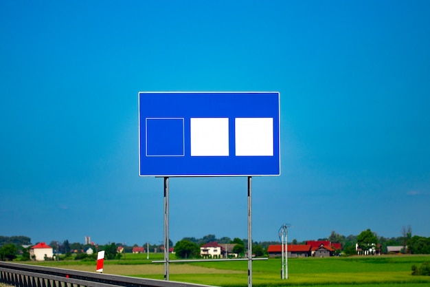 Segnale stradale grande autostrada vuota con cielo blu sfumato.