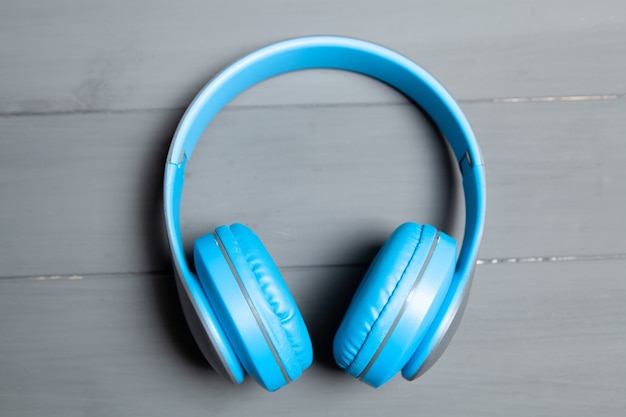 Big blue headphones on gray wooden table