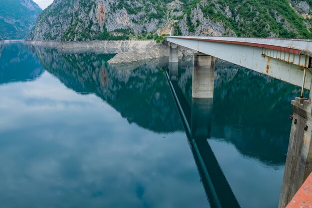 big bridge is crossed by a picturesque mountain lake.